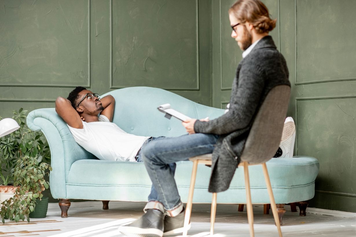 Man is lying on a comfortable counch while in a counselling session