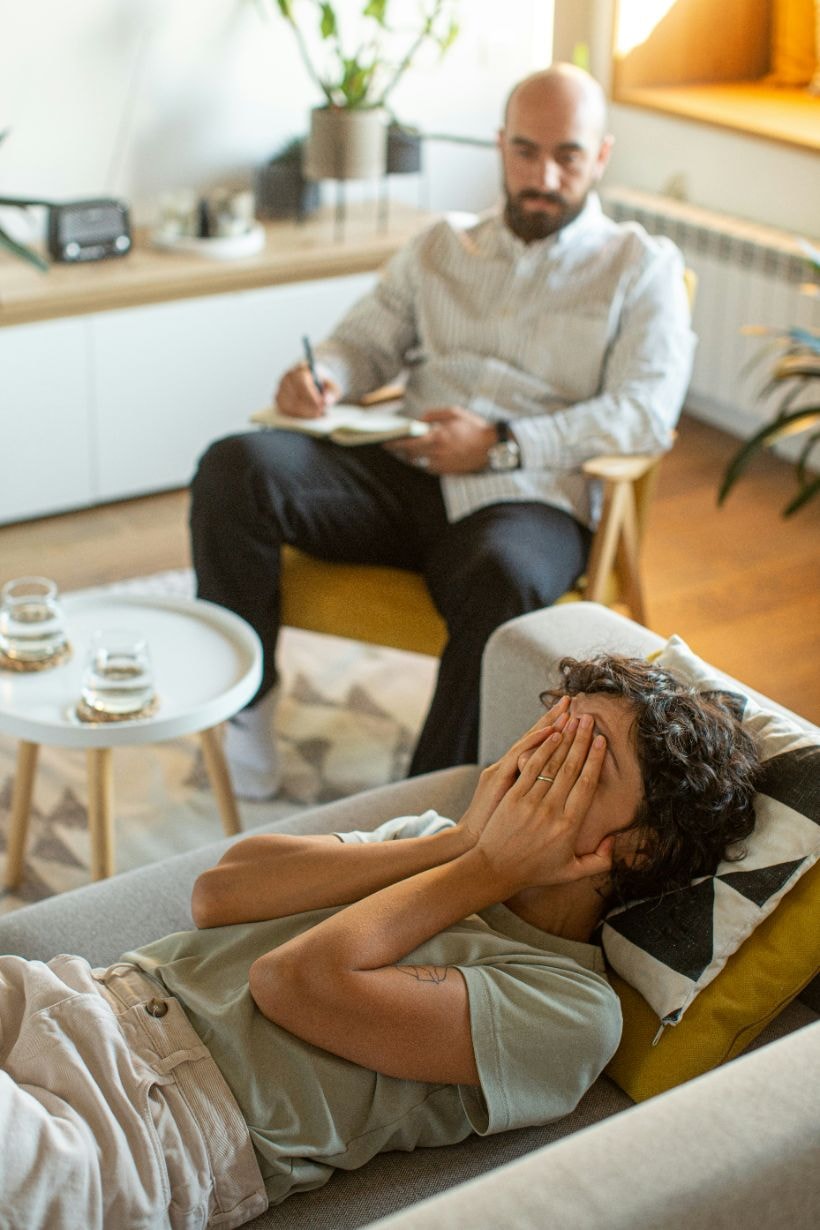 Female patient lying on a couch, depressed, with the counsellor