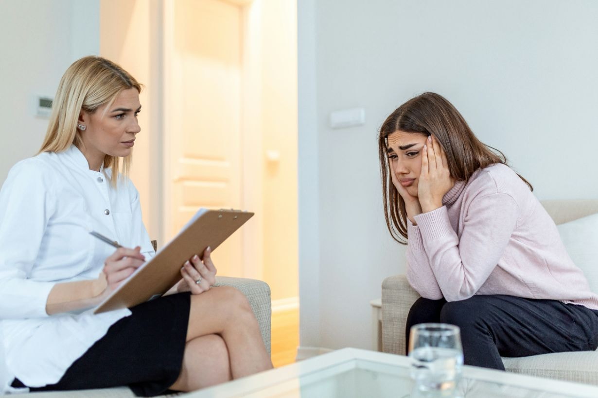 Upset young lady with a lady counsellor